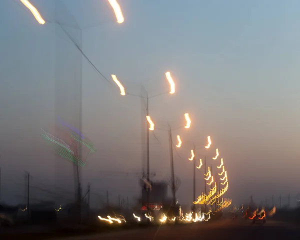 Luces en la carretera al atardecer — Foto de Stock