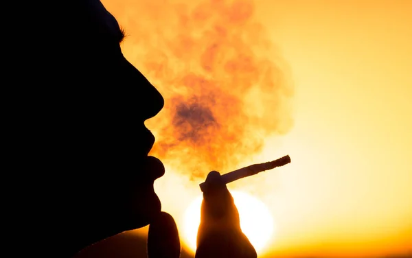 Silhouette of male smokers in the sunset — Stock Photo, Image