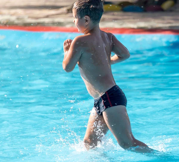 Pojke simmar med ett stänk i vattenparken — Stockfoto