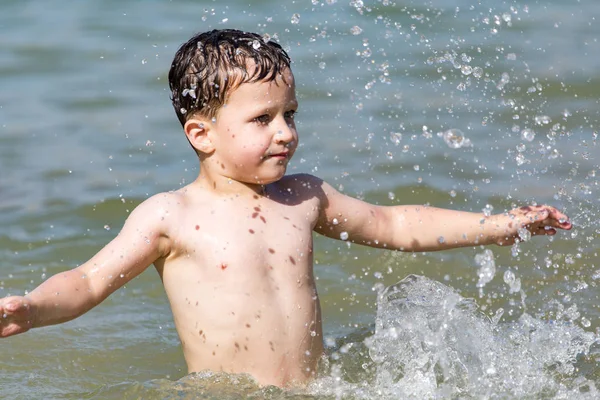 Pojke badar i sjön till stranden — Stockfoto