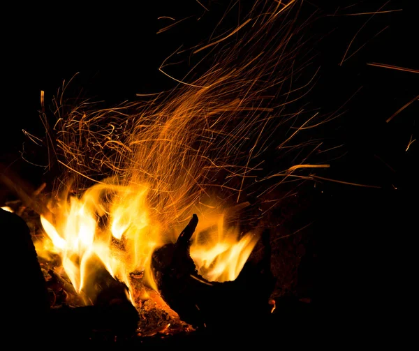黑色背景上喷出火花的火焰 — 图库照片