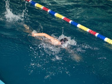 Çocuk havuza spor için giriyor.
