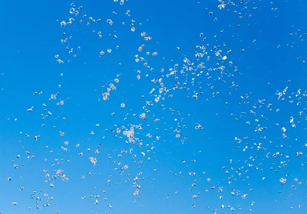 Spruzzi d'acqua dalla fontana sullo sfondo del cielo blu — Foto Stock