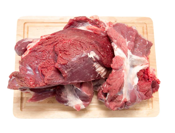 Carne em uma tábua em um fundo branco — Fotografia de Stock