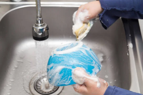 Boy washing dishes in the kitchen — Stock Photo, Image