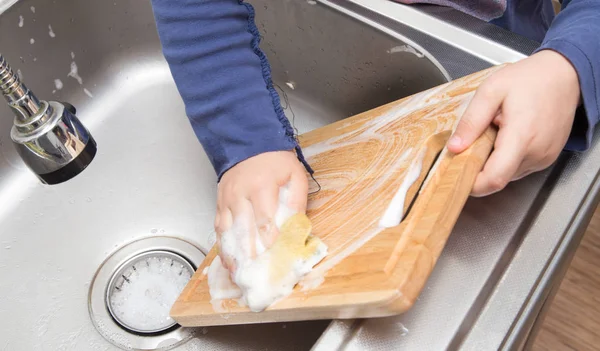 Niño lavando platos en la cocina —  Fotos de Stock