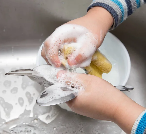 Niño lavando platos en la cocina — Foto de Stock
