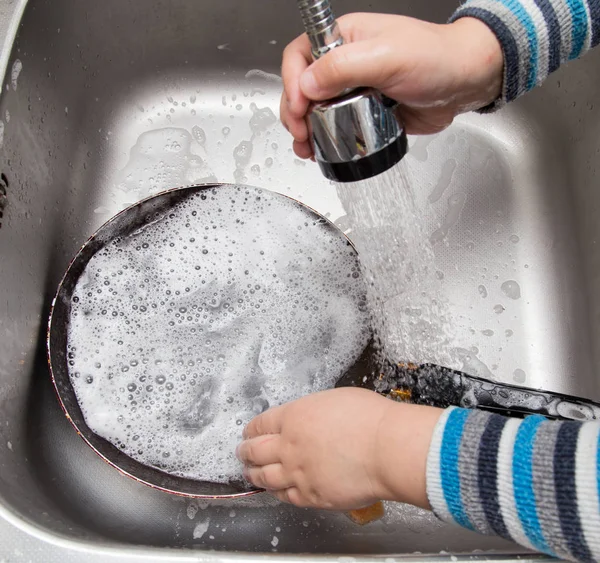 Chłopiec, zmywanie naczyń w kuchni — Zdjęcie stockowe