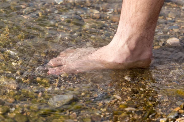 Mannelijke benen in water — Stockfoto