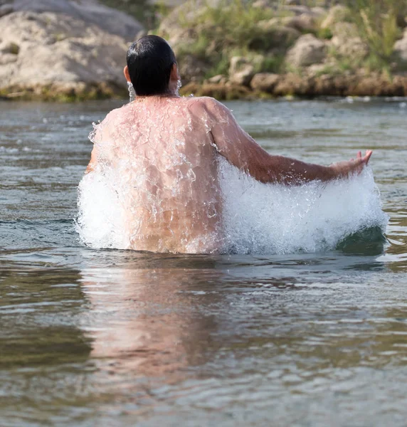 Een man springt uit het water — Stockfoto
