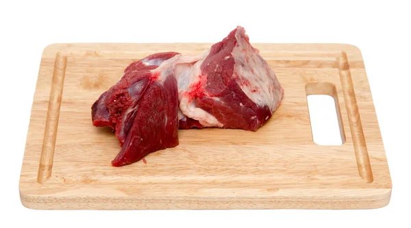 Carne em uma tábua em um fundo branco — Fotografia de Stock