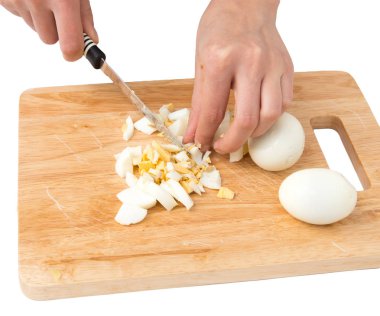 Beyaz bir arka plan üzerinde kesme tahtası üzerinde yumurta pişirmek