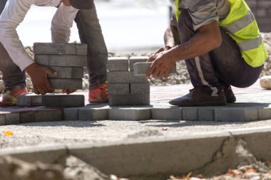 İşçi yola kaldırım taşı koyar