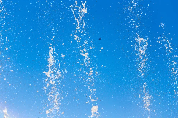 Éclaboussures d'eau de la fontaine dans le fond du ciel bleu — Photo