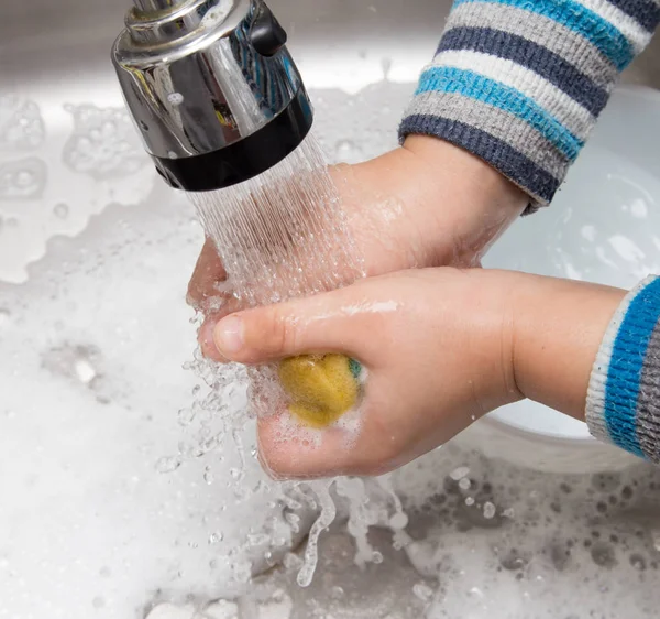 Junge spült Geschirr in der Küche — Stockfoto