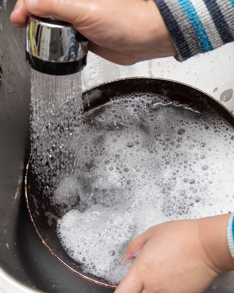 Junge spült Geschirr in der Küche — Stockfoto