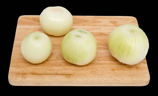Zwiebeln auf einem Brett auf schwarzem Hintergrund — Stockfoto