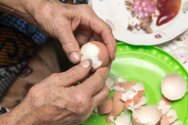 Бабушка чистит яйца — стоковое фото