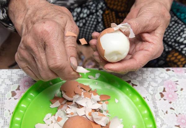 Granny cleans eggs — Stock Photo, Image