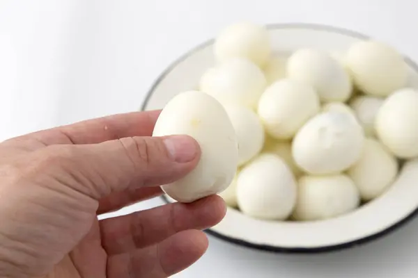 Jajka na twardo w rękę na białym tle — Zdjęcie stockowe