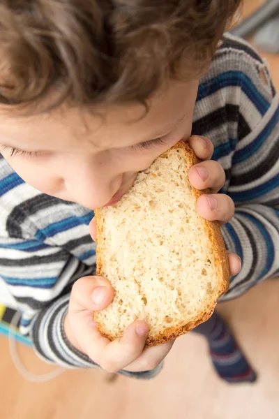 Junge isst Brot — Stockfoto