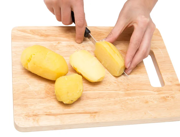 Шеф-повар режет вареный картофель на борту на белом фоне — стоковое фото