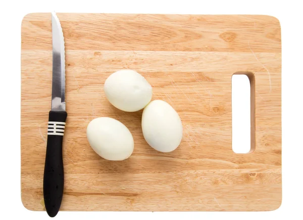 Koke egg på nedskjæringstavle på hvit bakgrunn – stockfoto