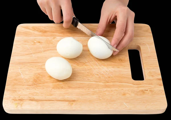 Eier auf Schneidebrett auf schwarzem Hintergrund kochen — Stockfoto