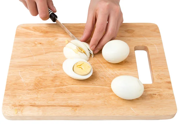 Варить яйца на разделочной доске на белом фоне — стоковое фото