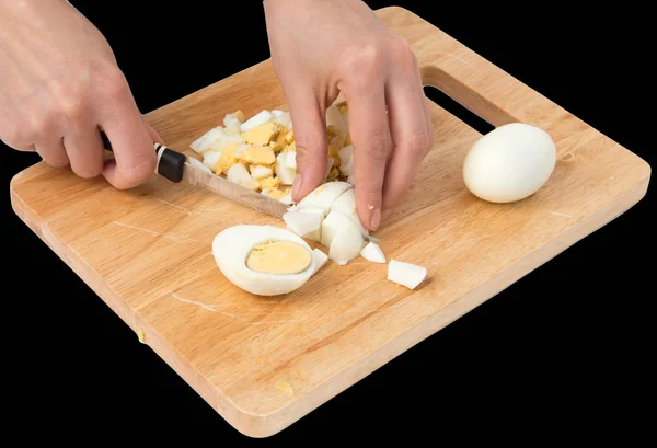 Варить яйца на разделочной доске на черном фоне — стоковое фото