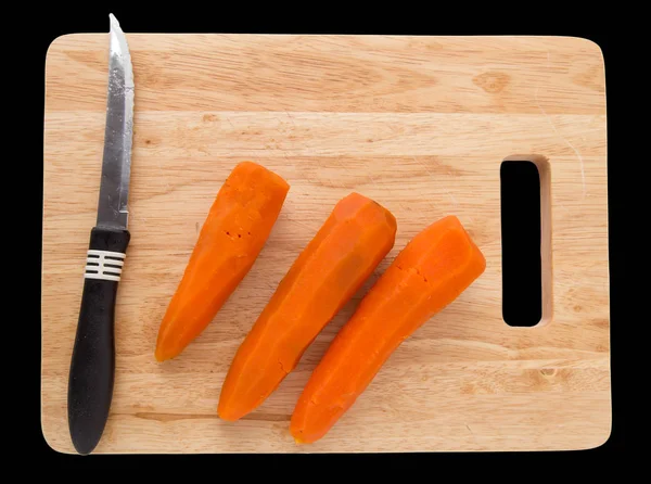 Zanahorias en un tablero sobre un fondo negro —  Fotos de Stock