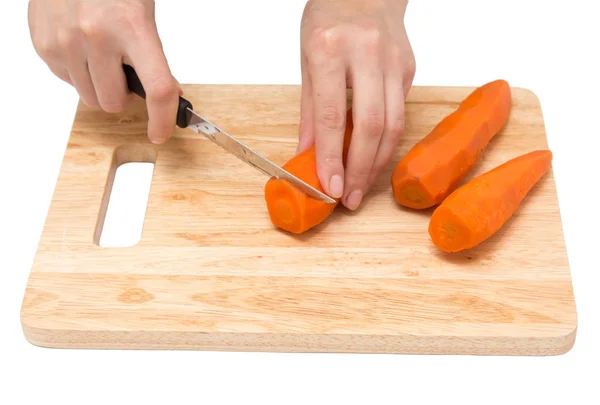 Cook snijdt wortelen op een witte achtergrond — Stockfoto