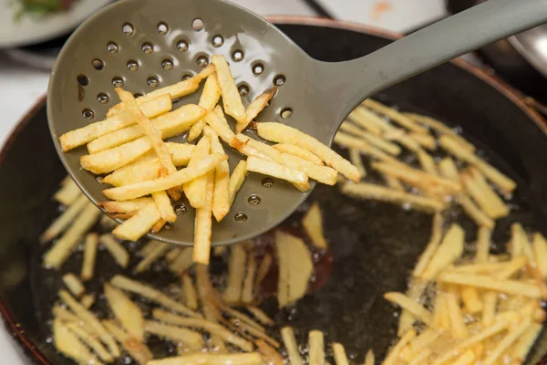 Cooking potato fries in oil — Stock Photo, Image