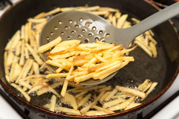 Cooking potato fries in oil — Stock Photo, Image