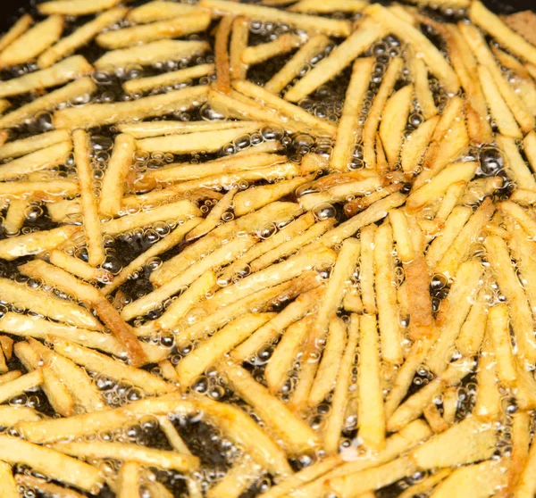 Cozinhar batatas fritas em óleo — Fotografia de Stock