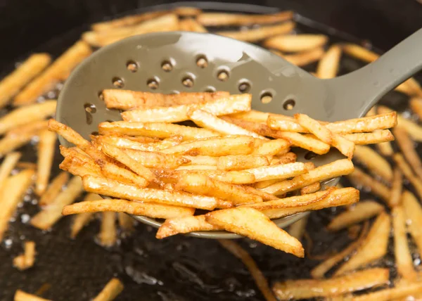 Cooking potato fries in oil — Stock Photo, Image