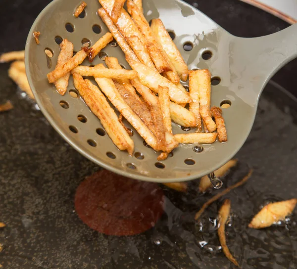 Cozinhar batatas fritas em óleo — Fotografia de Stock