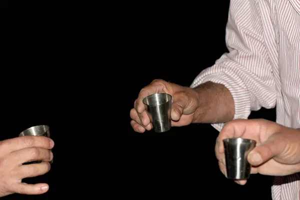 Three wine glasses in hands on a black background — Stock Photo, Image