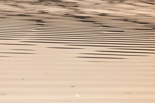 Uitgestrektheid van water op de zonsondergang achtergrond — Stockfoto