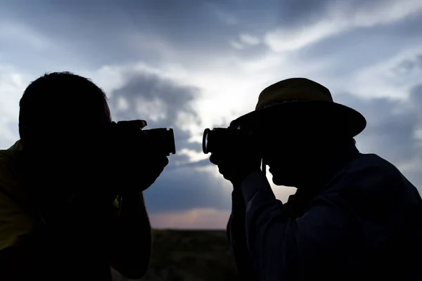 夕日を背景にカメラを持った男のシルエット — ストック写真