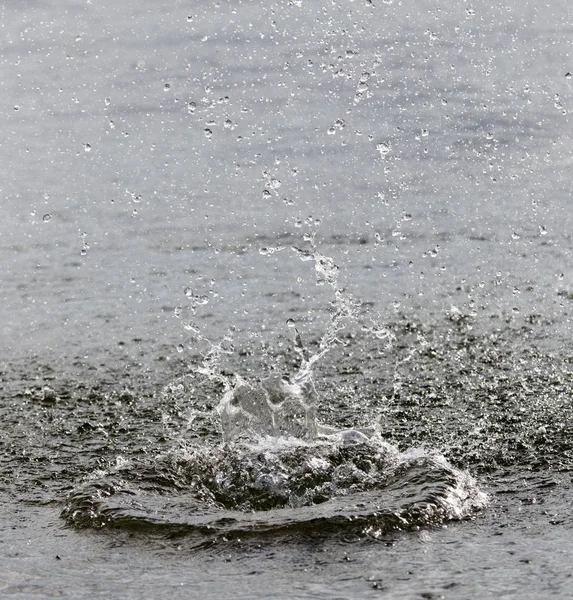 Wasser spritzt von einem Stein in den Fluss — Stockfoto