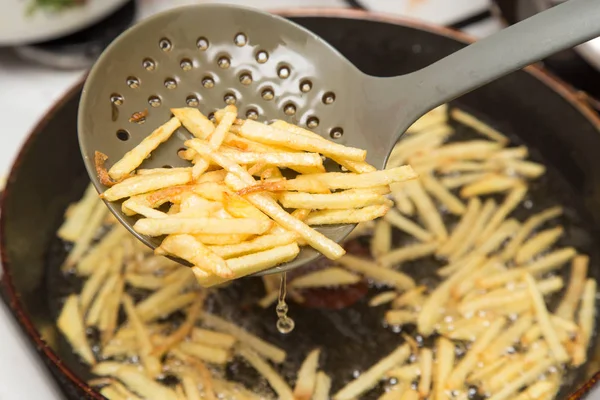 Cooking potato fries in oil — Stock Photo, Image