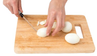 Beyaz bir arka plan üzerinde kesme tahtası üzerinde yumurta pişirmek