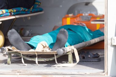 Ambulanstaki sedyedeki adam.
