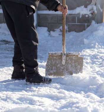İşçi kar küreği temizler