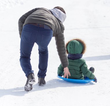 Baba çocuk bir kızak üzerinde rulo.