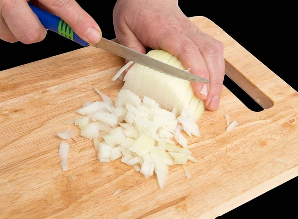 Cozinhe a cebola cortada em um conselho em um fundo preto — Fotografia de Stock