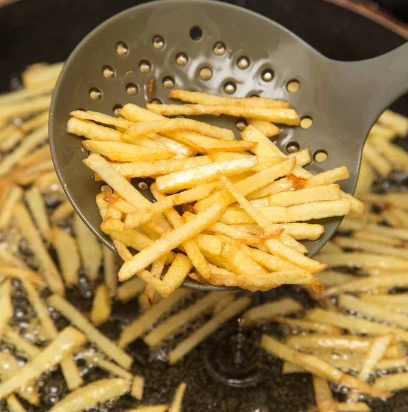 Cooking potato fries in oil — Stock Photo, Image