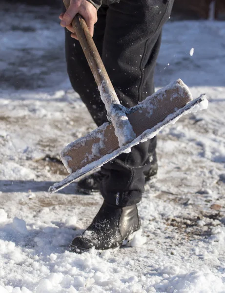Працівник очищає лопату від снігу — стокове фото