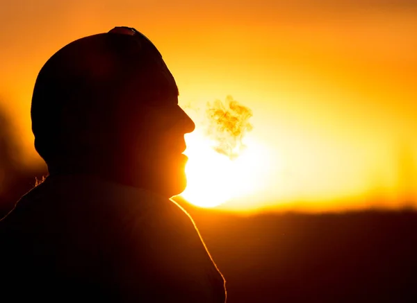 Férfi dohányosok sziluettje a naplementében — Stock Fotó
